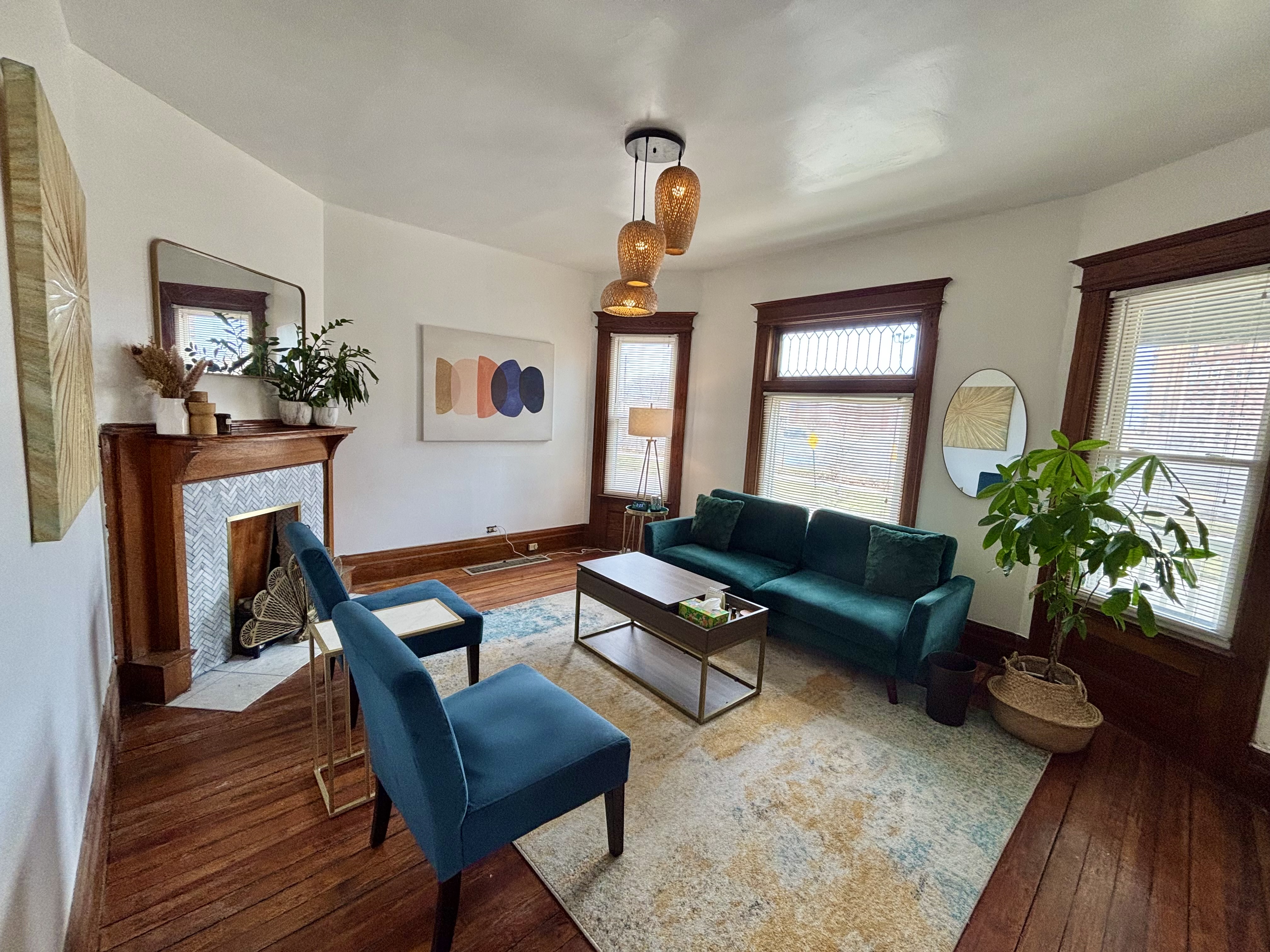 A large therapy office with a couch and chairs.