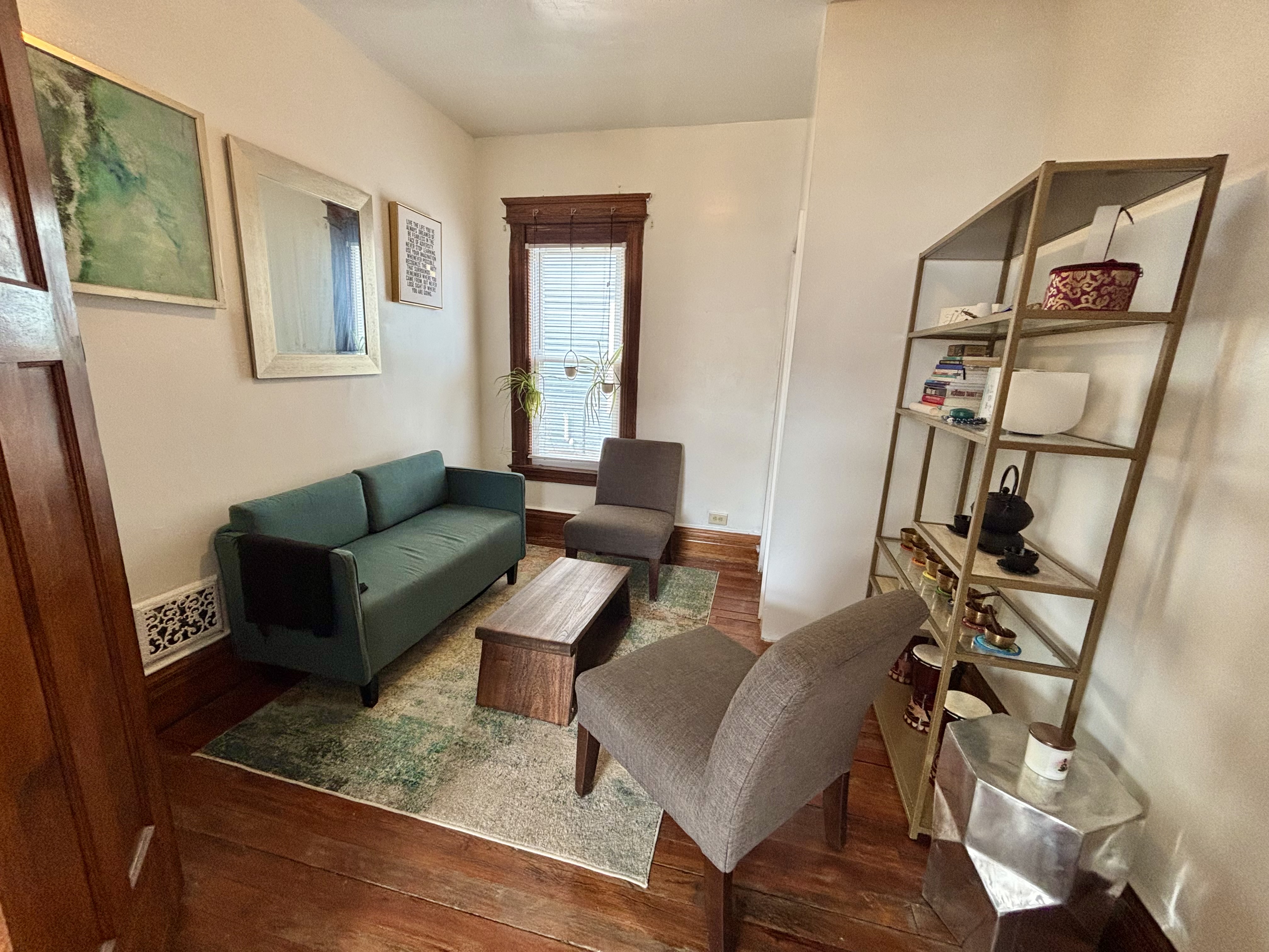 A therapy office with musical instruments and a couch and chair.